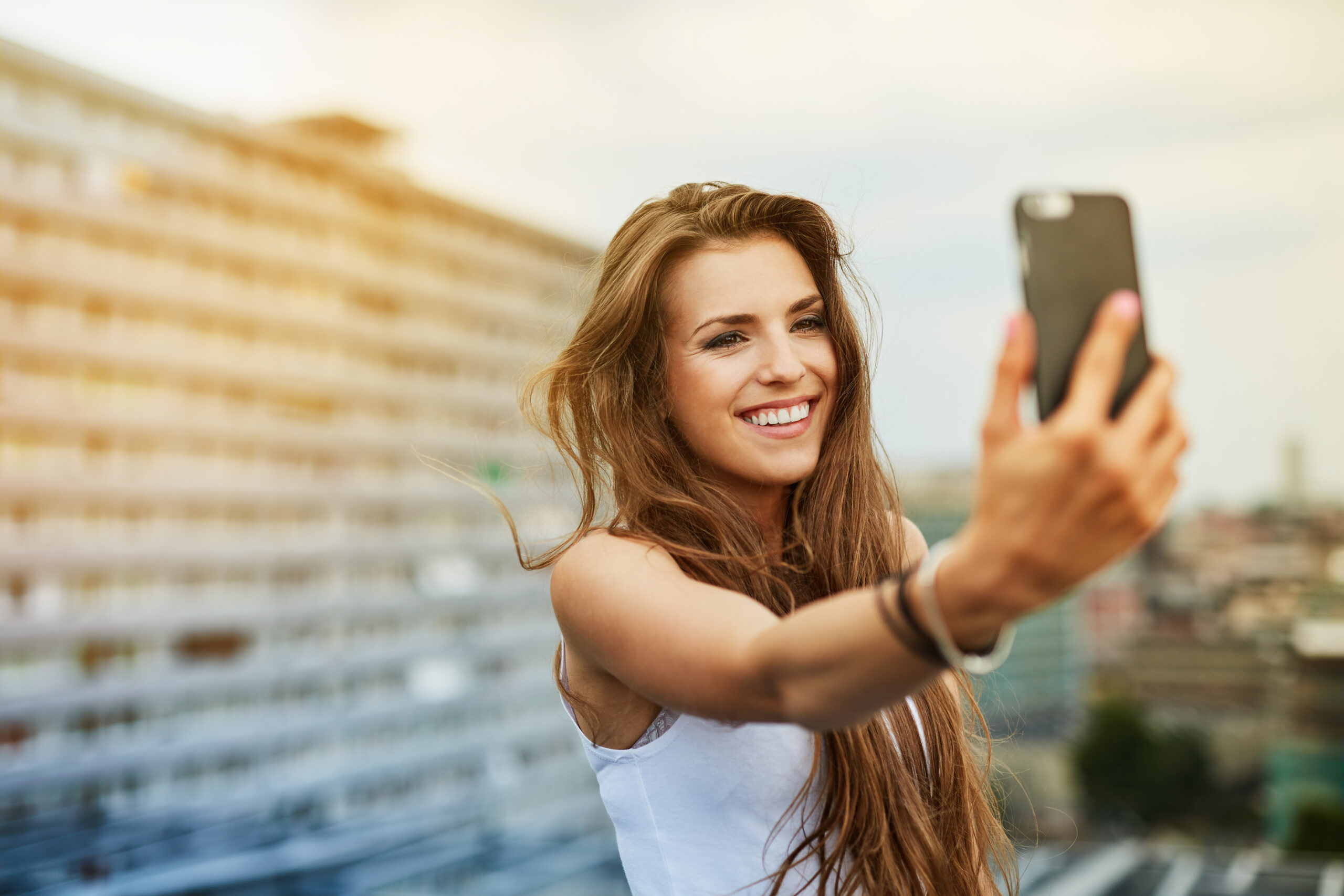 Frau mit langen braunen Haaren mit Selfie