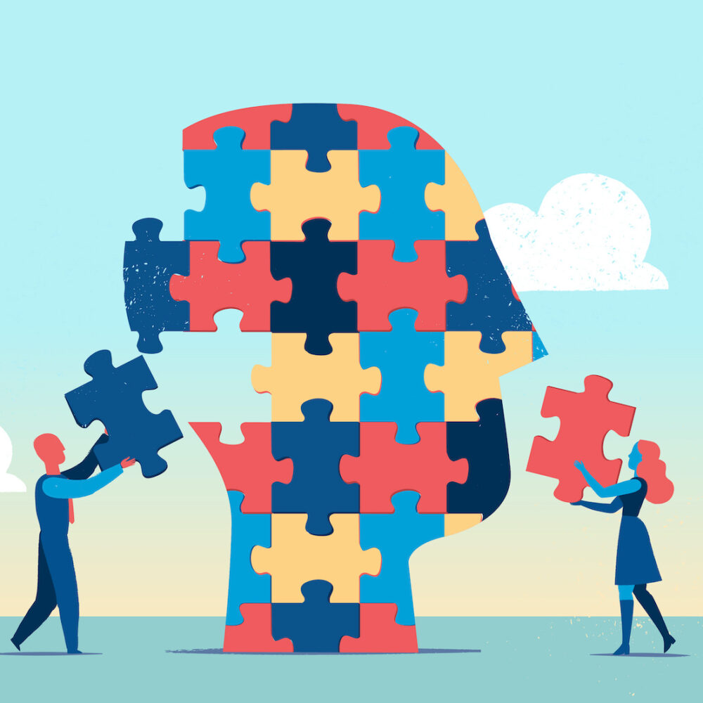 Teamarbeit: Personen die Kopf aus Puzzleteile zusammensetzen